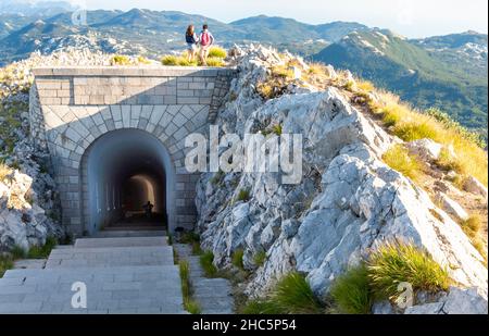 Lovcen National Park,Montenegro-September 14 2019: At sunset,a young couple,at the summit of Mount Lovcen,stand atop the connecting tunnel after visit Stock Photo