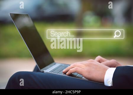 Businessman with laptop searching information in internet. Internet search bar. Online search. Networking concept. Stock Photo