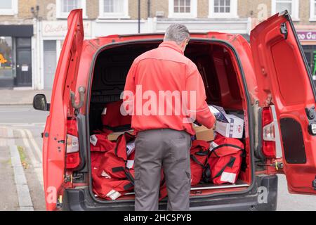 Santa Postman  open the rear doors delivering and distributing Christmas presents to local community in south London England UK Stock Photo