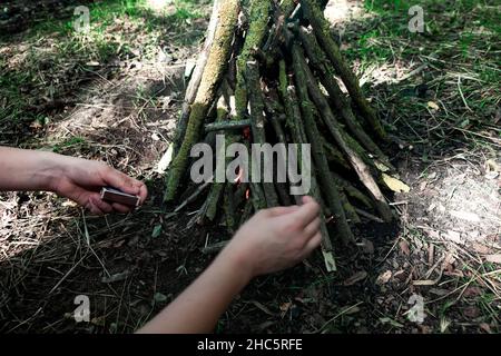 Logs in a pile for picnic . Burning matches in the hands Stock Photo