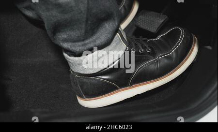 Accelerator and breaking pedal in a car. Close up the foot pressing foot pedal of a car to drive ahead. Driver driving the car by pushing accelerator Stock Photo