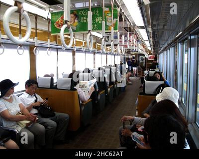 Interior design local train and japanese people and foreign travelers passenger inside use service journey work and travel by railway in Arashiyama st Stock Photo