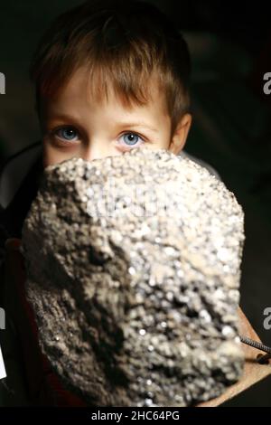 Child examines natural mineral in Geological Museum Stock Photo