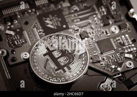one bitcoin coin lies on a computer board Stock Photo