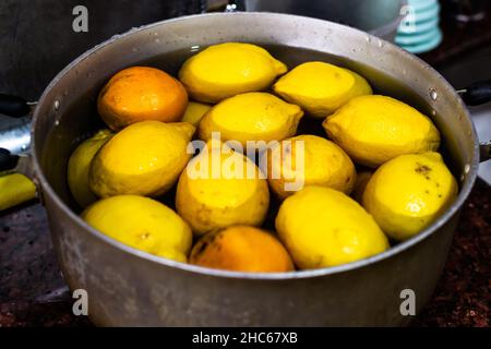Closeup of bright yellow lemons in a pot full of water Stock Photo