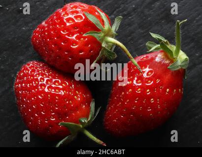 Photography of three strawberries on slate for food background Stock Photo