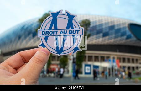 September 12, 2021, Marseille, France. The emblem of the football club Olympique de Marseille against the background of the modern stadium.