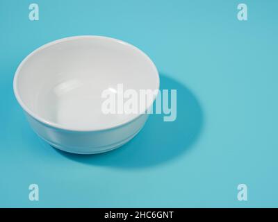 empty white bowl on blue background. minimalist style. Stock Photo