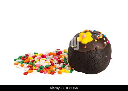 Delicious homemade chocolate ball topping with multicolored rainbow sprinkles and sugar flower and a pile of rainbow sprinkles on white background wit Stock Photo