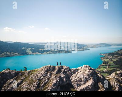Drone view of two people standing on top of the Schoberstein summit at the Attersee in Upper Austria, Austria Stock Photo