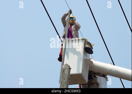Electricians work together on the electric cable car and electric pole. Stock Photo