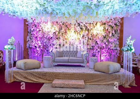 An elegantly staged traditional MOROCCAN style wedding with large sofa for the wedding couple to sit and receive blessings from the guests, surrounded Stock Photo