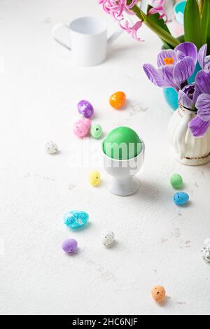 One green Easter eggs and decoration eggs on light table Stock Photo