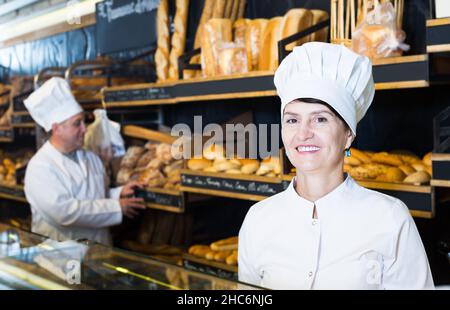 Bakery female employee with tasty bread products Stock Photo