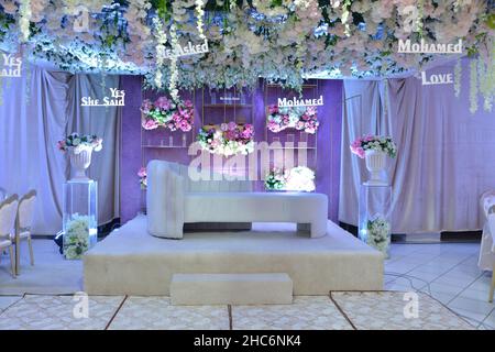 An elegantly staged traditional MOROCCAN style wedding with large sofa for the wedding couple to sit and receive blessings from the guests, surrounded Stock Photo