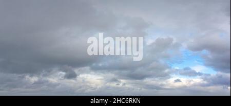 dramatic sky with a small window of blue sky Stock Photo
