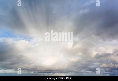 dramatic sky with rays of sunlight breaking through from behind the clouds Stock Photo