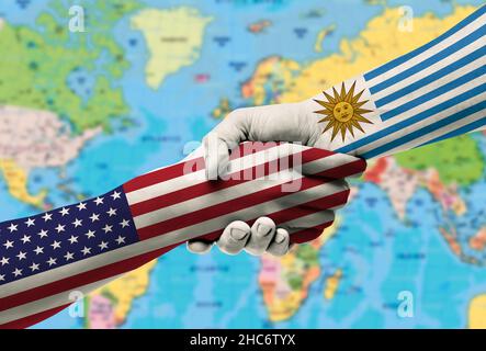 Handshake between United States and Uruguay flags painted on hands.With background of world map Stock Photo