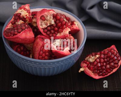 Fresh organic pomegranate slices in a bowl. Low key. Close up. Stock Photo