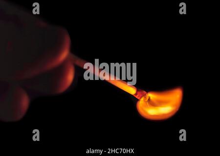 Hand with a match igniting on a dark background Stock Photo