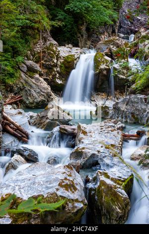 Vertical shot of waterfalls flowing through rocks and trees Stock Photo