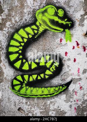 Vertical shot of a graffiti of a green snake on the wall of an old building, Bergen, Norway Stock Photo