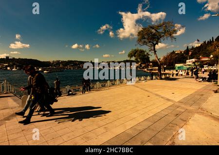Two men walking on the street and others enjoying the Bosphorus in Istanbul Stock Photo