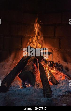 Several logs of wood burning in a home fireplace. Stock Photo