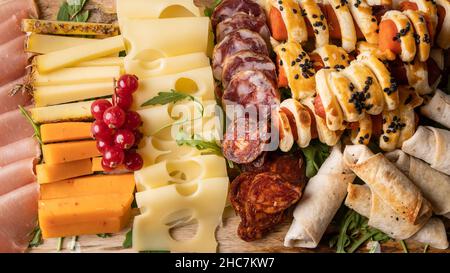 Close up on appetizer food on the table cheese and sausage rolls full frame Stock Photo