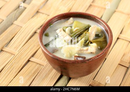 Sayur Lodeh or Vegetables with Coconut Milk Soup. Traditional Indonesian Culinary Food from Java in Traditional Bowl served on Bamboo Table. Selective Stock Photo