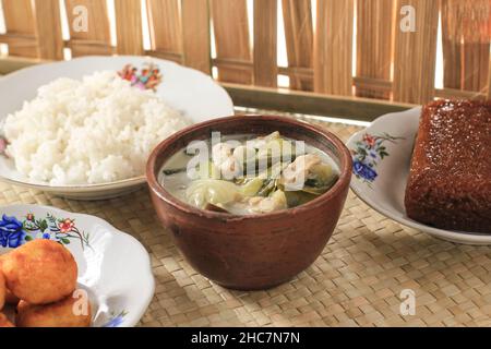 Sayur Lodeh or Vegetables with Coconut Milk Soup. Traditional Indonesian Culinary Food from Java in Traditional Bowl served on Bamboo Table. Selective Stock Photo