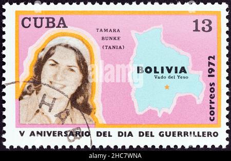 CUBA - CIRCA 1972: A stamp printed in Cuba from the '5th Anniversary of The Day of Guerrillas' issue shows Tamara Bunke (Tania) and map of Bolivia, c Stock Photo