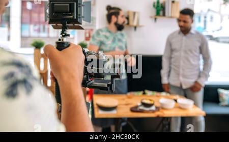 Unrecognizable camera operator recording cooking workshop Stock Photo