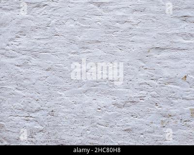 White textured stucco wall background. White stucco wall. Background of a white stucco coated and painted exterior, rough cast of cement and. White ba Stock Photo