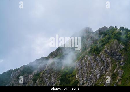 Germany, Tegelberg mountain summit in allgaeu nature landscape in foggy atmosphere, an adventurous hike to the top Stock Photo