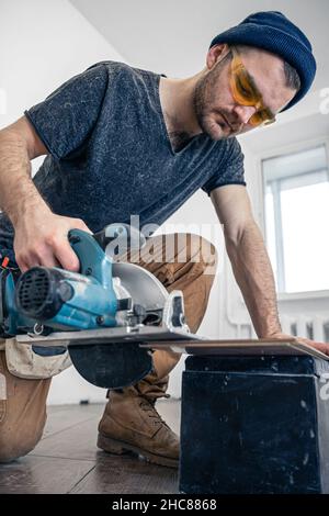 Circular Saw, carpenter using a circular saw for wood. Stock Photo