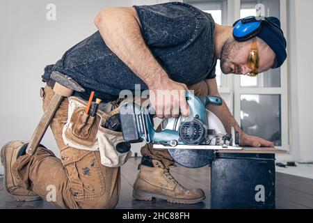 Circular Saw, carpenter using a circular saw for wood. Stock Photo