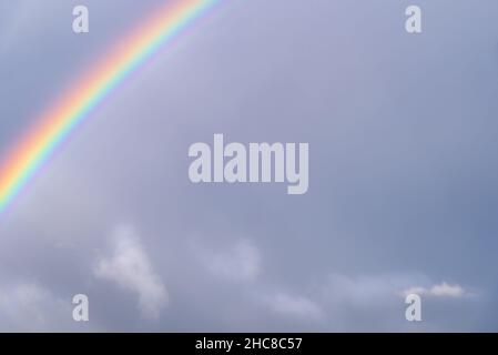 Rainbow on a background of the cloudy sky. Stock Photo