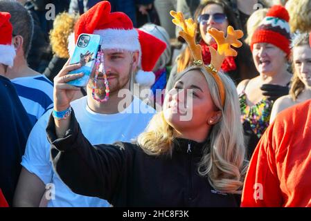 Paignton, Devon, UK.  26th December 2021.  UK Weather.  Swimmers in festive fancy dress take to the sea on Boxing Day for the Lion’s Club Walk in to the Sea at the beach at Paignton in Devon on an unseasonably  warm sunny day.  Picture Credit: Graham Hunt/Alamy Live News Stock Photo