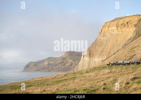 West Bay, UK. 26th December, 2021. Empty benches at the cliffs of West Bay, Dorset. Credit: Liam Asman/Alamy Live News Stock Photo