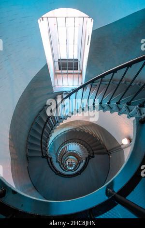 Looking down circular staircase inside historic lighthouse Stock Photo