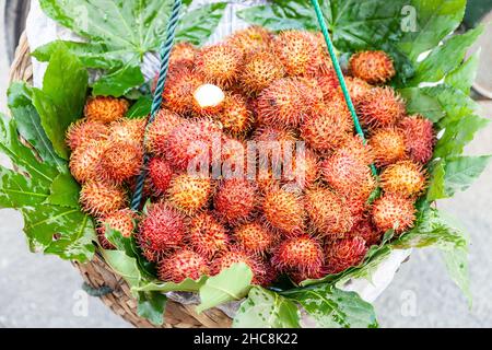 Basket of fresh lychees offered for sale on a street in Suzhou, China Stock Photo