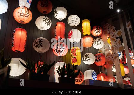 Traditional chinese lanterns lights inside asian restaurant. Paper decorations in fashionable cafe Stock Photo