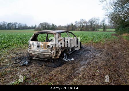 Burnt Out Volkswagen Golf GTi Car in Field Stock Photo