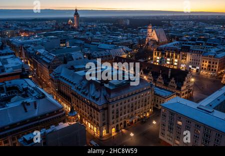 Leipzig, Germany. 25th Dec, 2021. The illuminated city center of Leipzig with the Hotel Steigenberger in the Handelshof, Old City Hall (l-r), New City Hall and St. Thomas Church on the evening of Christmas Day. (Aerial view with drone) Credit: Jan Woitas/dpa-Zentralbild/dpa/Alamy Live News Stock Photo
