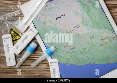 Covid home testing kits laying on a table next to a map of Mexico Stock Photo