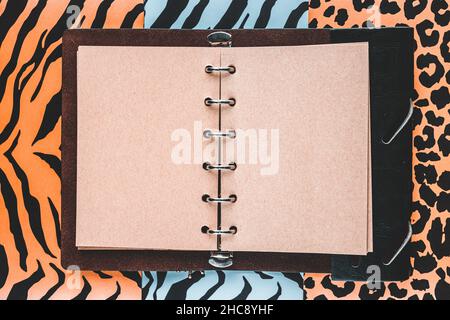Open handmade paper notebook with space for text, Wild, freedom and nature background, Three colorful patterns of tiger, jaguar and zebra skin, Flat l Stock Photo