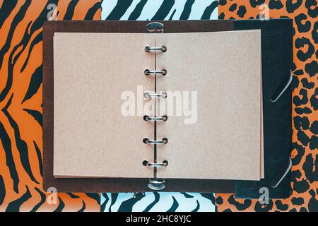 Open handmade paper notebook with space for text, Wild, freedom and nature background, Three colorful patterns of tiger, jaguar and zebra skin, Flat l Stock Photo