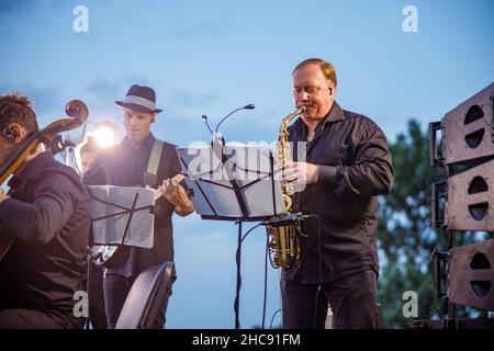Saxophone player playing in orchestra on the street Stock Photo