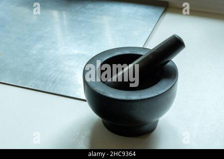 Dark stone kitchen mortar on the countertop, close up Stock Photo